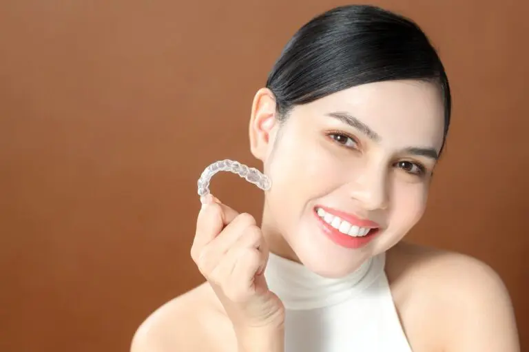 young woman beautiful teeth holding invisalign clear aligners healthy dental concept - Can Invisalign Fix Overbite in Burtonsville, MD