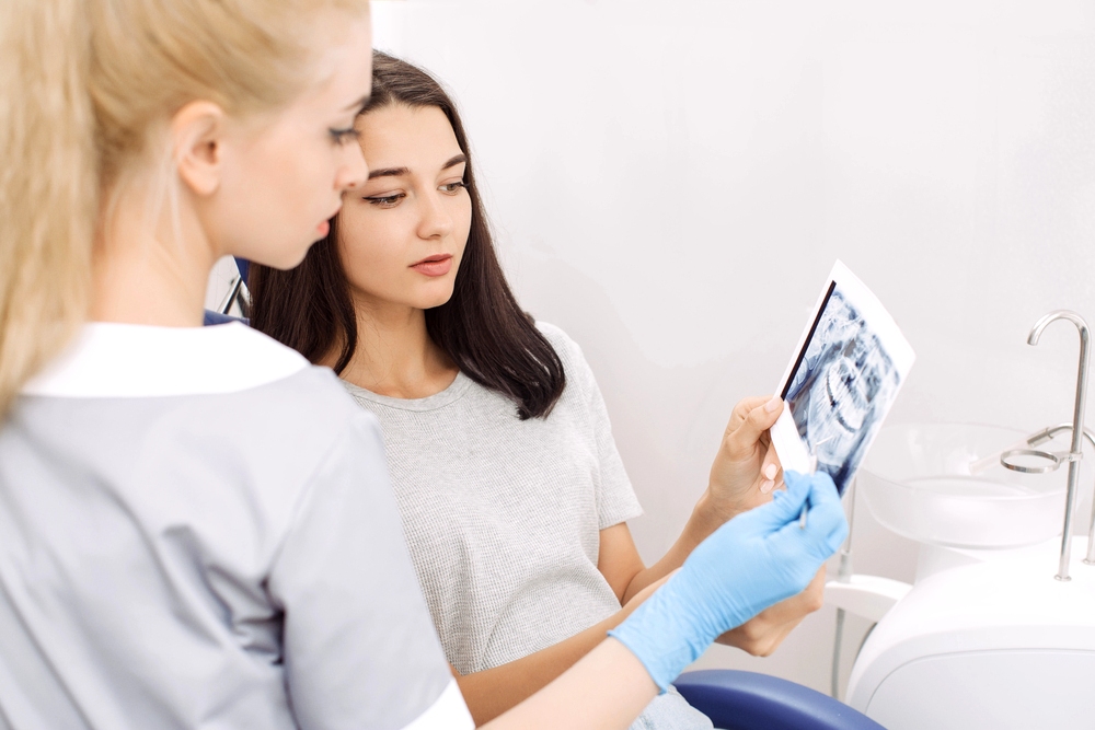 Orthodontist showing a dental X-ray to a patient during consultation – How to Fix Overbite in Burtonsville, MD.