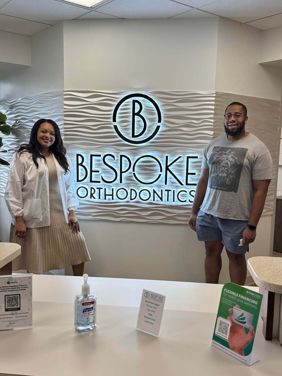 A woman in a white coat and a casually dressed man after free orthodontic consultation at BeSpoke Orthodontics in Burtonsville, MD.