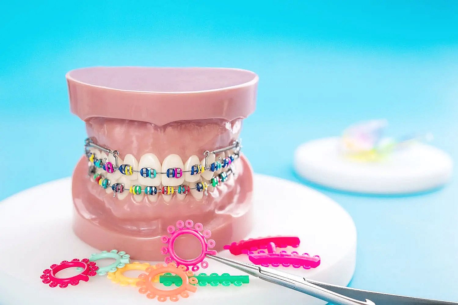 A dental model with colorful metal braces sits beside bands and a dental tool at BeSpoke Orthodontics in Burtonsville, MD.