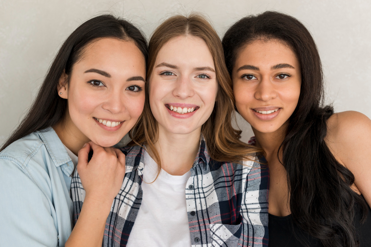 Smiling young women stand close together represent benefits and considerations of adult orthodontics at BeSpoke Orthodontics in Burtonsville, MD.