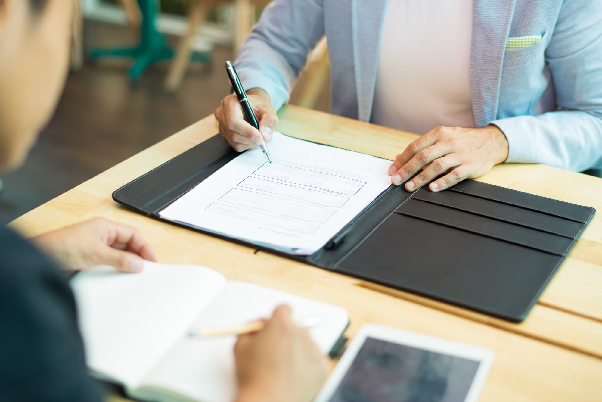At BeSpoke Orthodontics in Burtonsville, MD, two people discuss an Invisalign Payment Plan at a table with documents and a tablet.